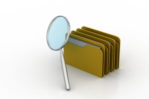 A magnifying glass next to evidence folders.