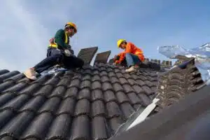 A group of construction workers do work on a roof top on a sunny day